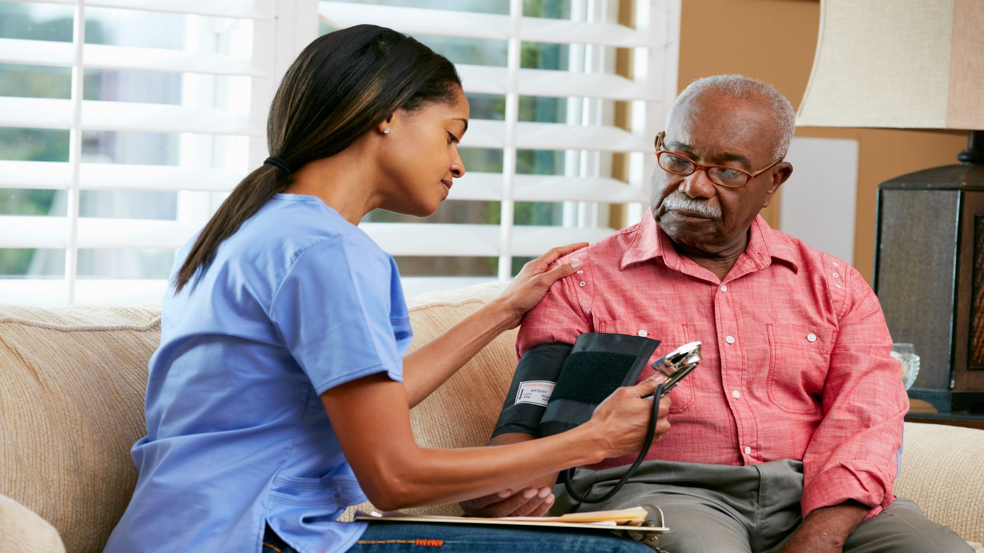 Aide measuring blood pressure